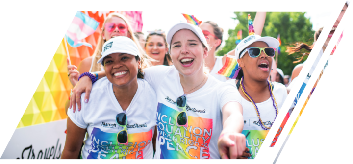 People in a crowd wear inclusion, equality and human rights shirts 