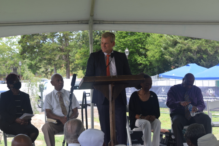 Cliff Fleet at podium with four people seated behind him