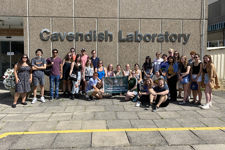 A group stands in front of a building that says Cavendish Laboratory