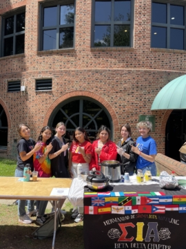 Women beind a table with food for sale on it