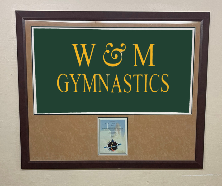 A framed W&M gymnastics flag