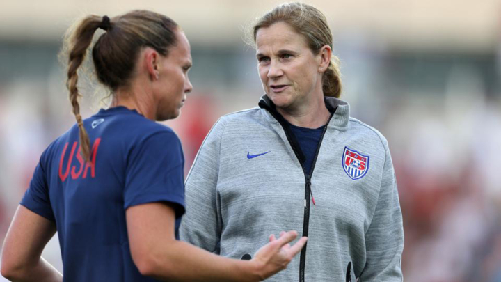 Jill Ellis talks to a soccer player.