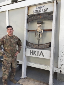 Man standing in front of Camp Courage sign