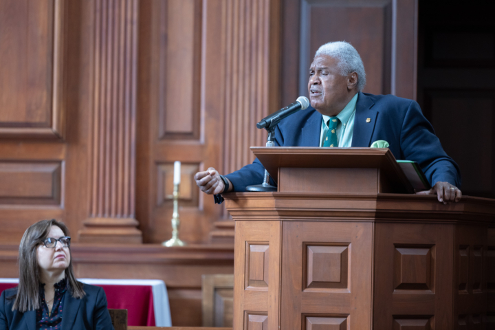 Judge John Charles Thomas delivers a keynote address in the Wren Building Chapel while Provost Agouris looks at him.