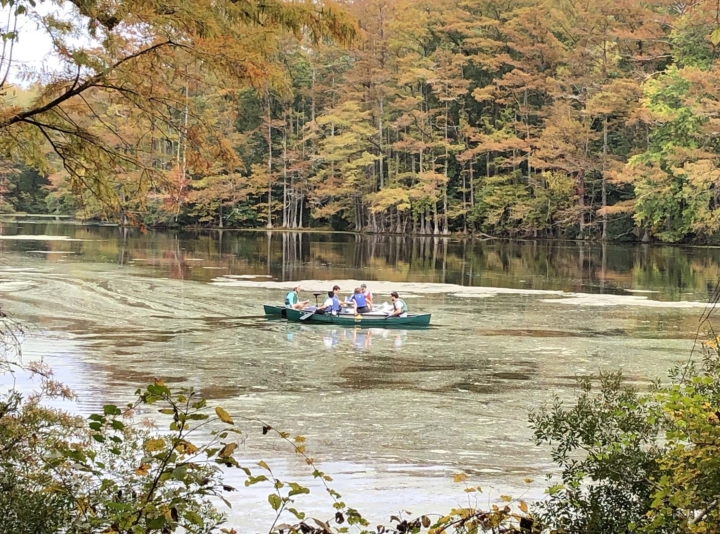 W&M students in a canoe collecting sediment core from Jolly Pond, a former millpond in Williamsburg.