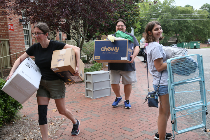 People carry boxes and other goods.