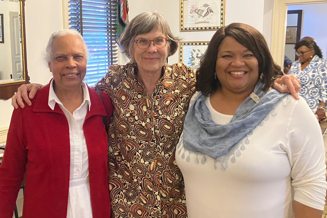 Three people pose for a photo together.