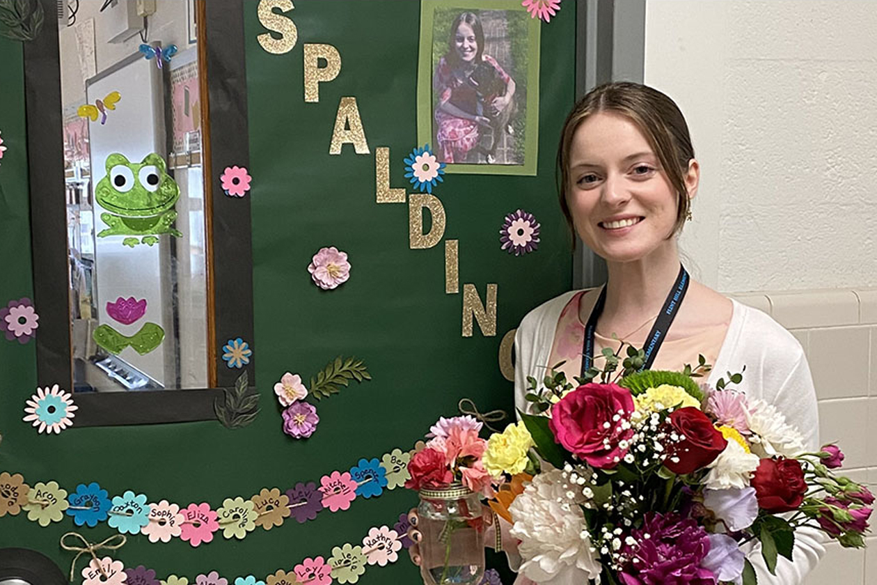 Erin Spalding '23, M.Ed '24 is going to Thailand as a Fulbright Scholar. She poses in front of the classroom where she teaches sixth grade in northern Virginia.