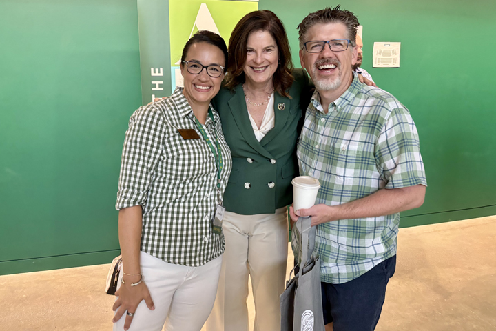 Three people pose for a photo together.