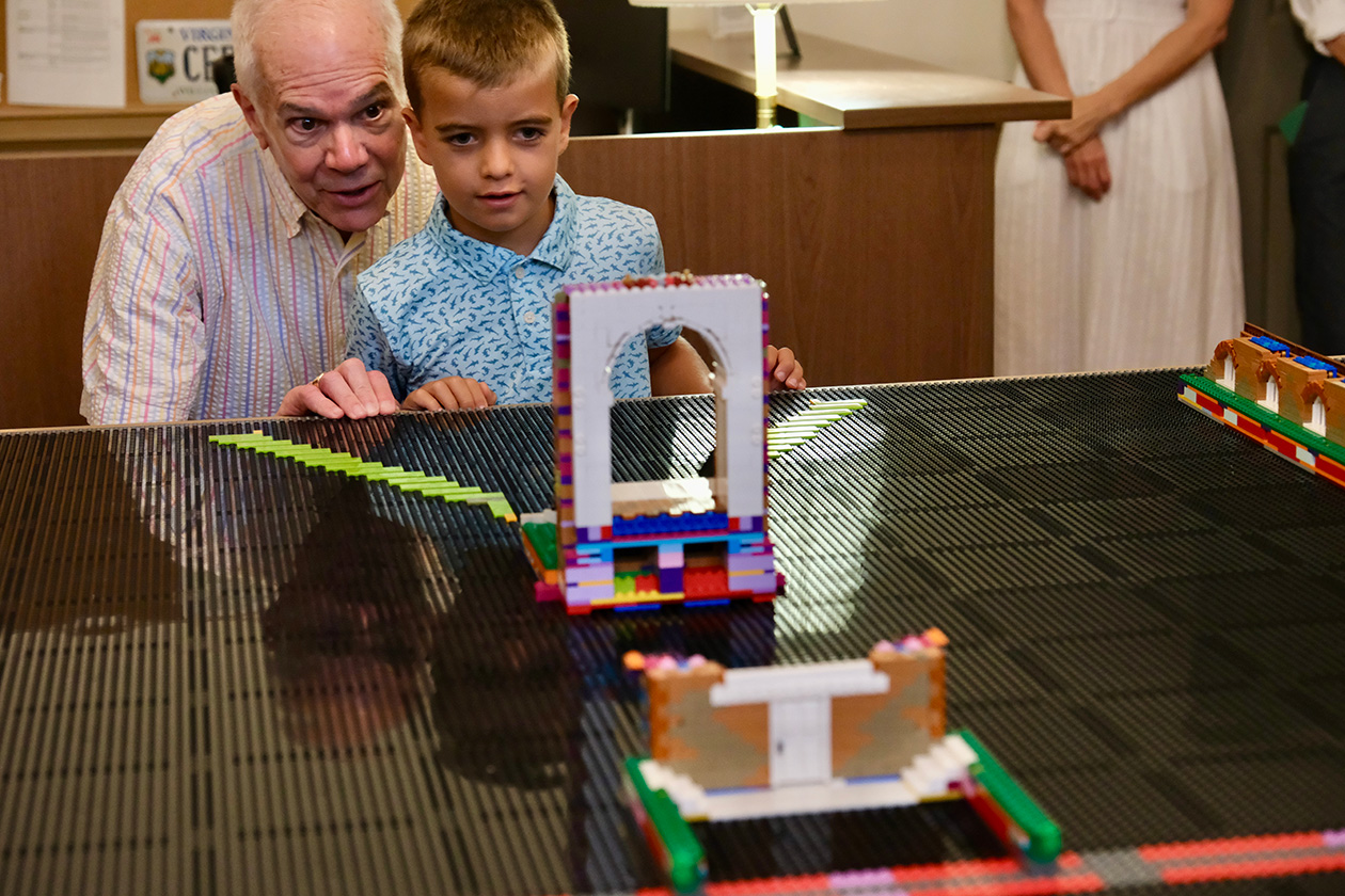 Alumni Bruce Christian '73 and his grandson, Maks, admire the Lego model of the Wren Building's west steps, which they assembled and installed as the first piece of a planned Lego model of the Historic Campus.