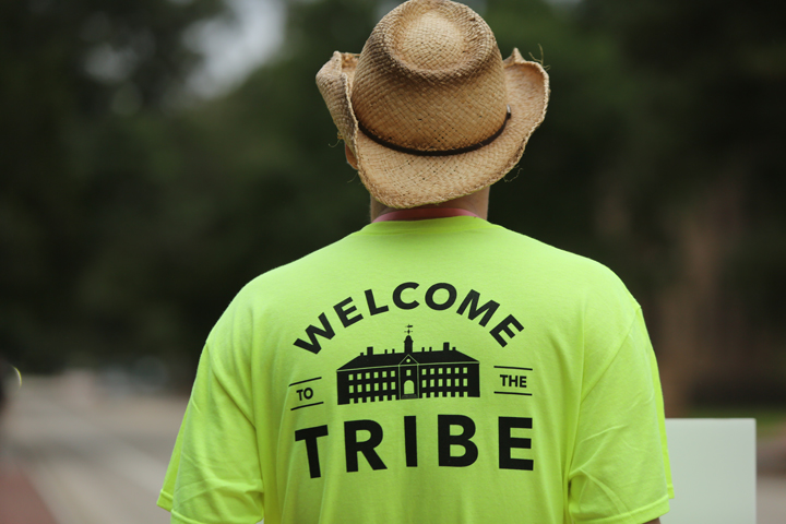 The back of a person's shirt says "Welcome to the Tribe."