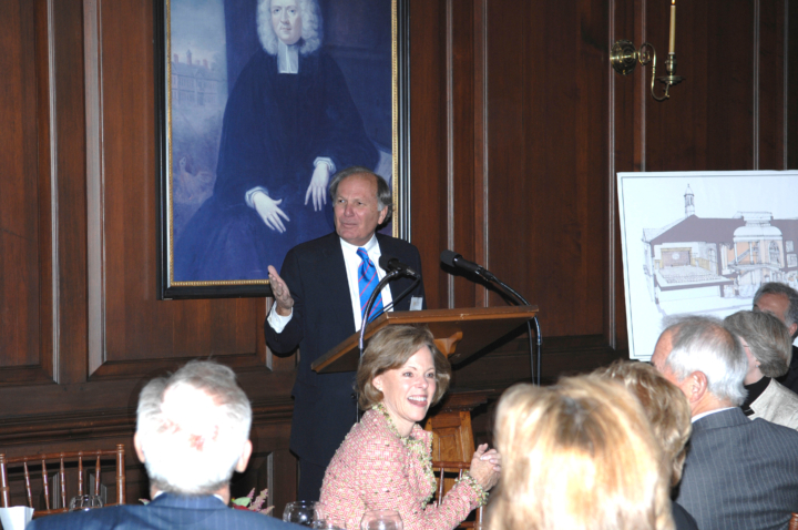 A person gestures while standing at a podium.