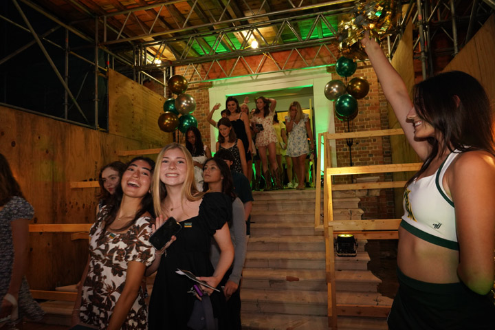 A line of people streams down wooden steps under scaffolding.