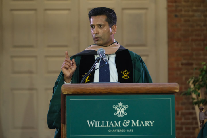 Darpan Kapadia stands at a podium wearing academic regalia.