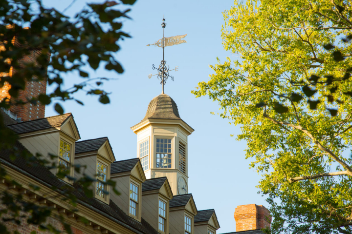 A weathervane is visible atop a cupola on a large building.