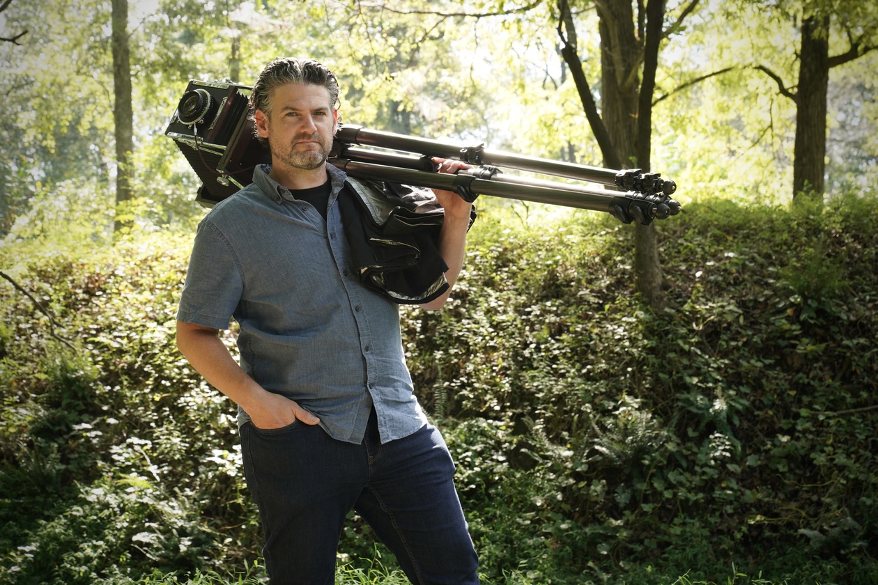 Professor of Photography poses with his large view camera for a story about 20 of his photographs being acquired by the Library of Congress