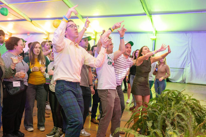 People point and wave while dancing.