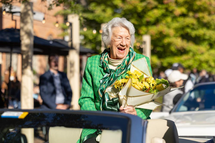 Jane Batten holds flowers and smiles.