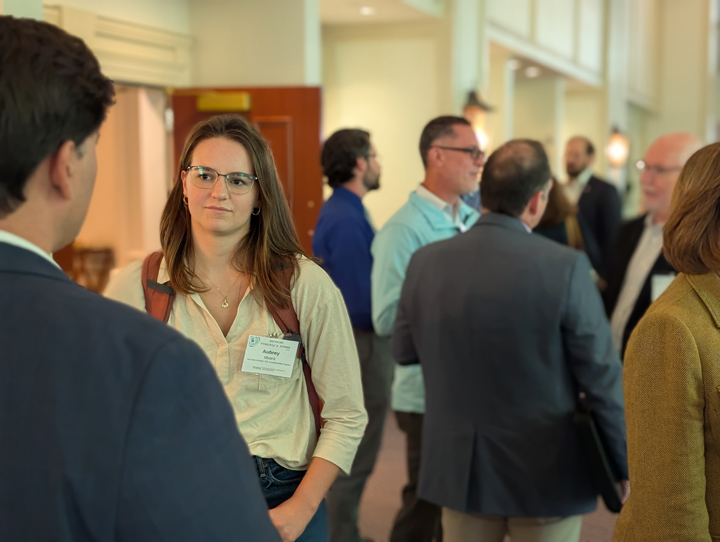 People stand in a hallway and talk in small groups.