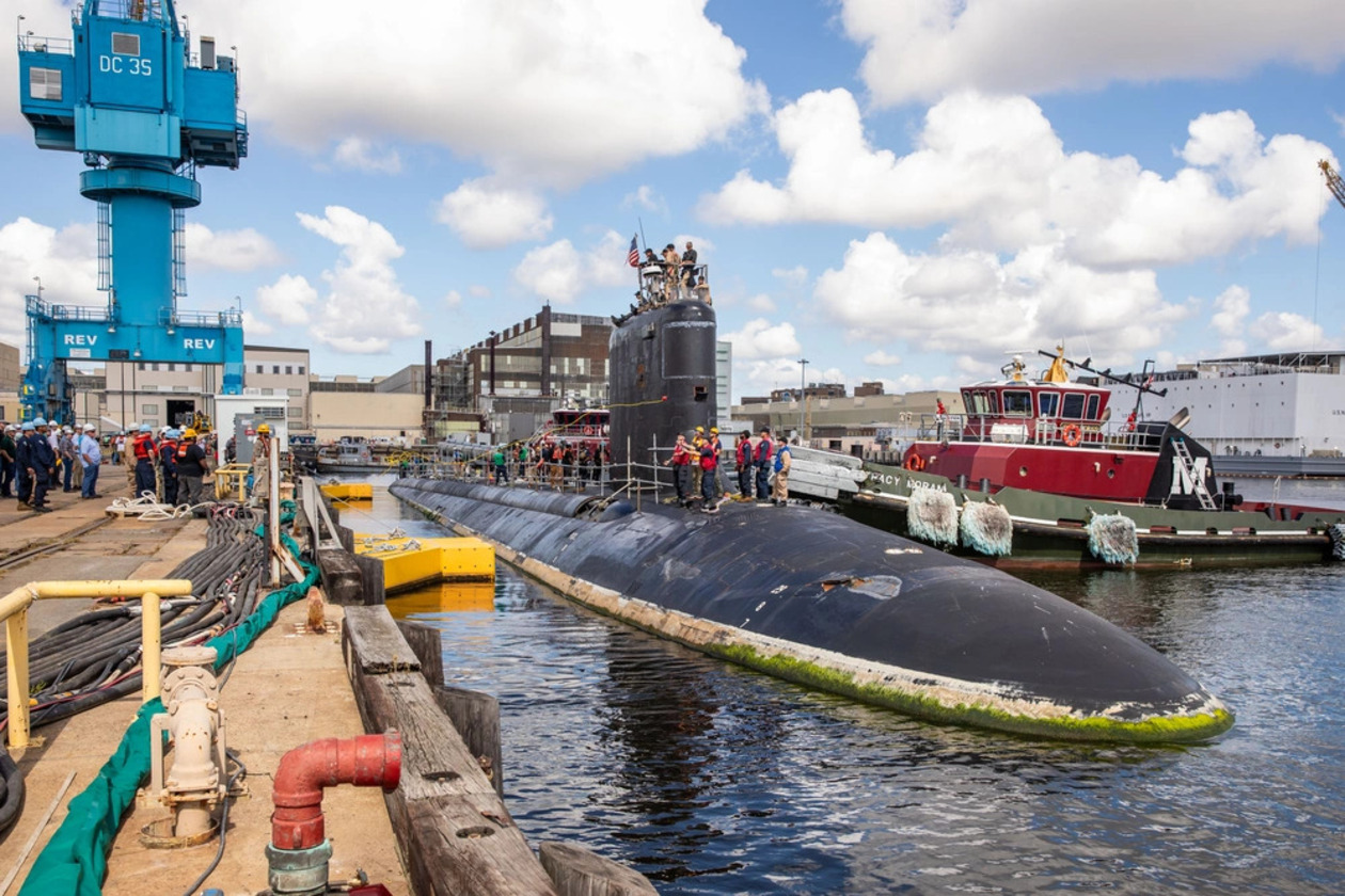 A submarine sits at a dock.