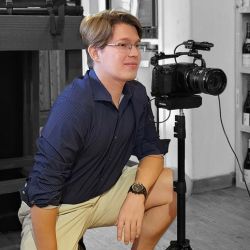 Kuenzli kneels next to a camera.