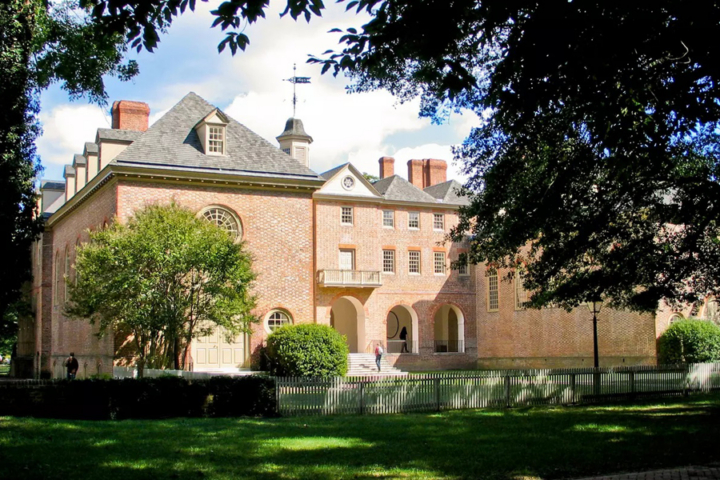 Tree branches frame a large, brick building.