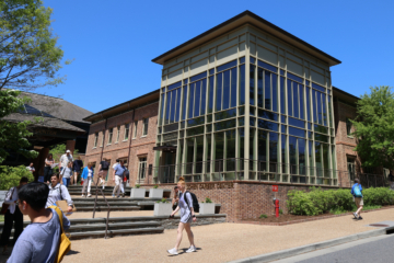 People wearing backpacks walk outside of the Cohen Career Center.