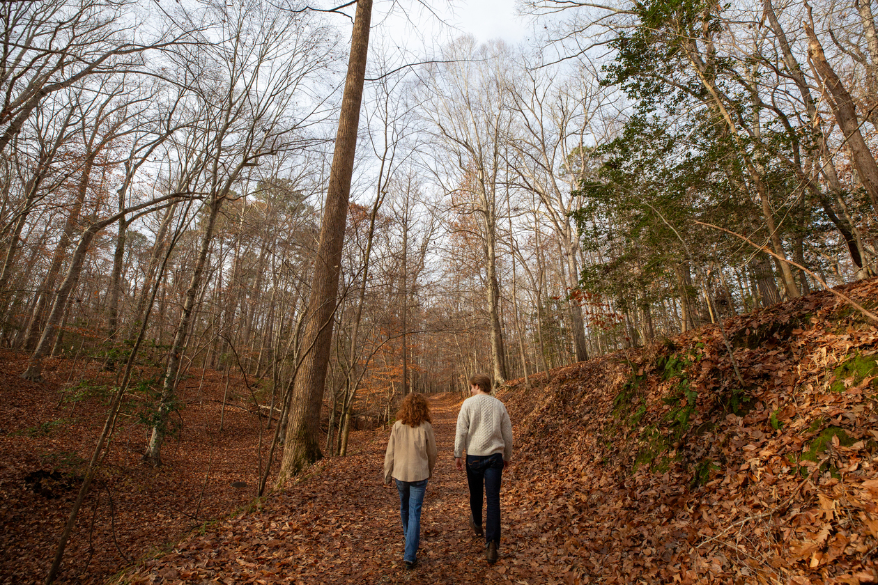 This photo depicts two young people walking through the College Woods, adjacent to the William & Mary campus