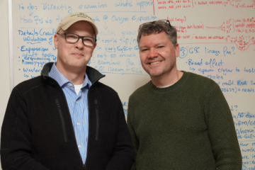 Photo of two professors in front of a whiteboard
