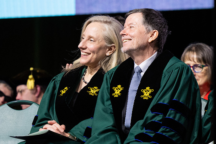 Abigail Spanberger and Ken Burns smile while sitting next to each other.