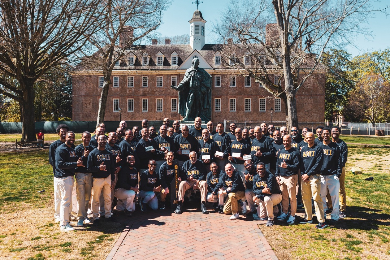 This is a photo of members of the Kappa Pi Chapter of Alpha Phi Alpha, the first National Pan-Hellenic Fraternity at William & Mary, gathered on campus in May 2025 for their 50th anniversary celebration.