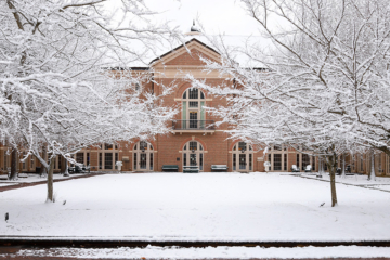 Snow covers the trees and ground outside of Miller Hall.