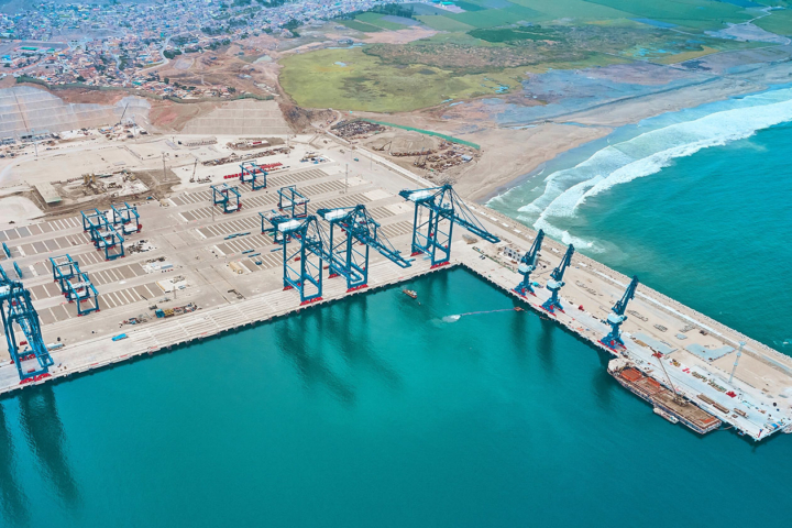 An aerial view of a port shows a docks and several cranes to be used for offloading and loading ships.