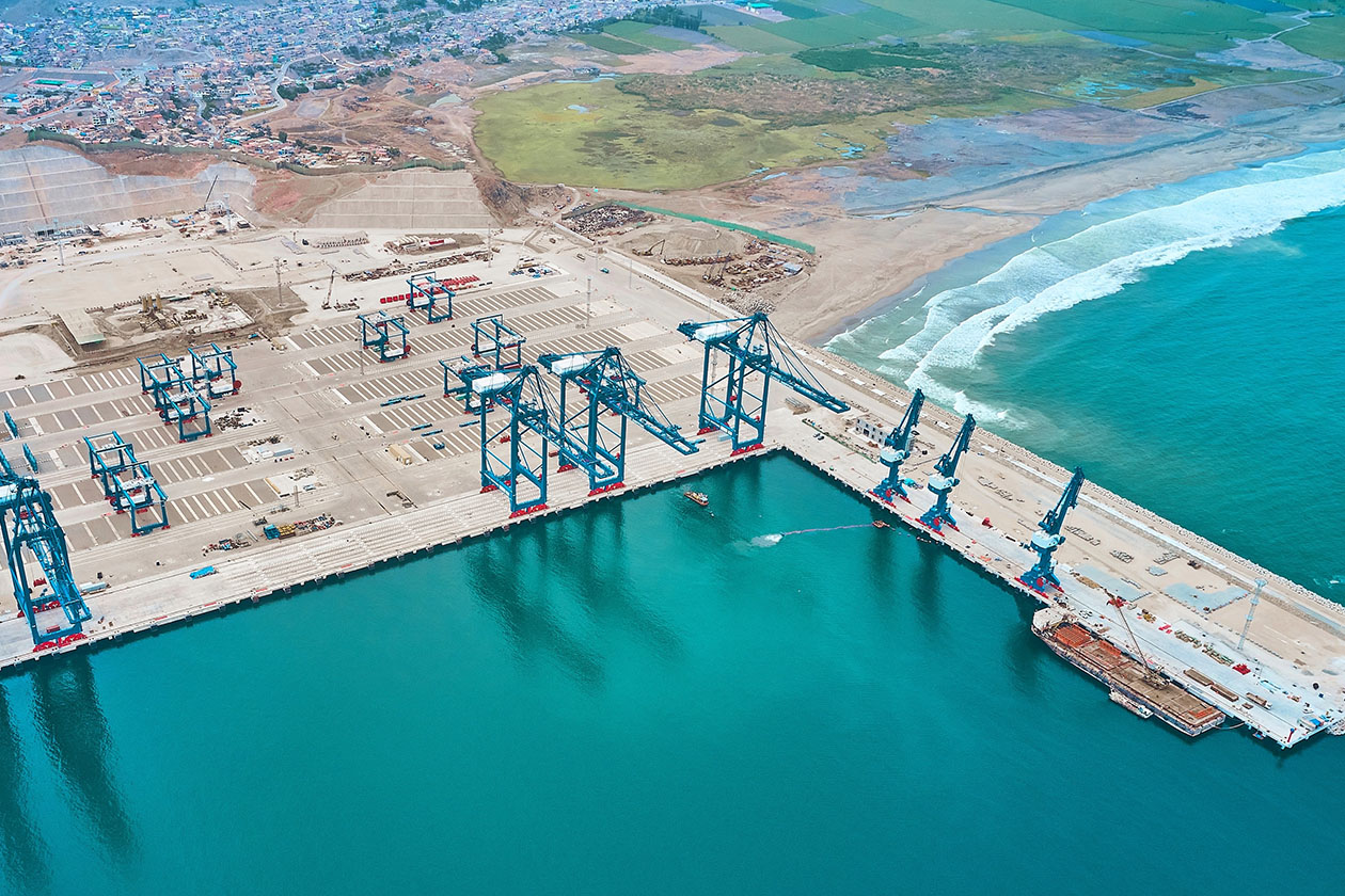 An aerial view of a port shows a docks and several cranes to be used for offloading and loading ships.