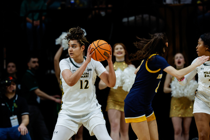 A basketball player holds a ball on the court.