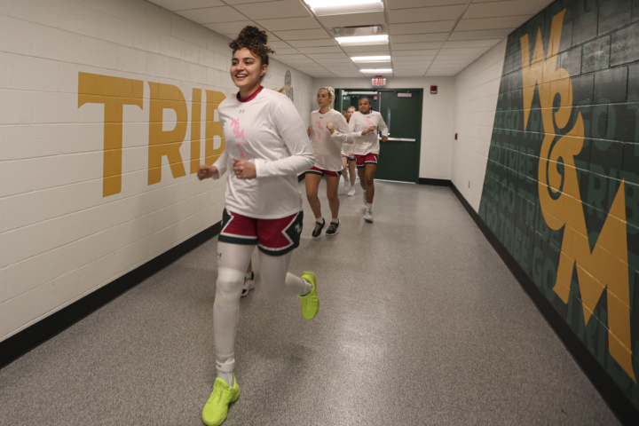 Basketball players run down a hallway.