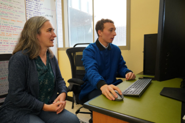 Photo of two people in front of a computer.