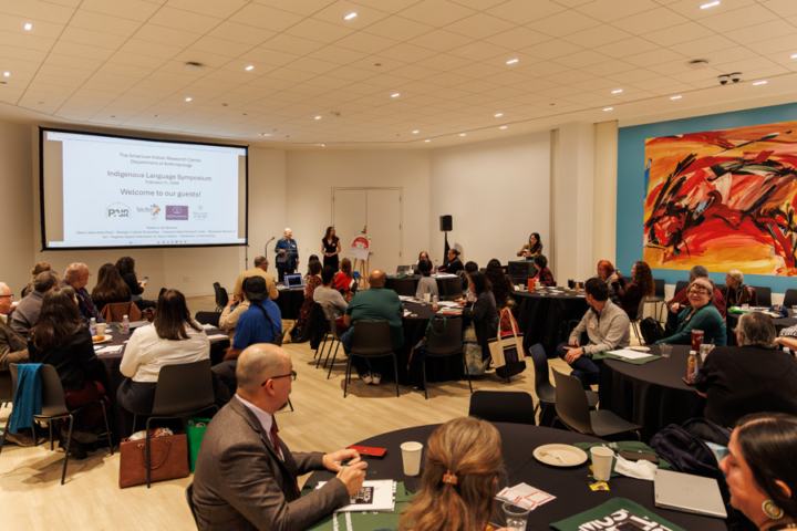 People sit at tables in a large room.