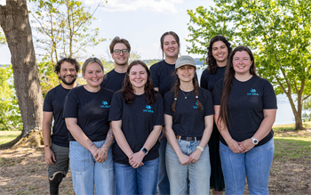 Eight people in matching VA SEA shirts take a photo together.