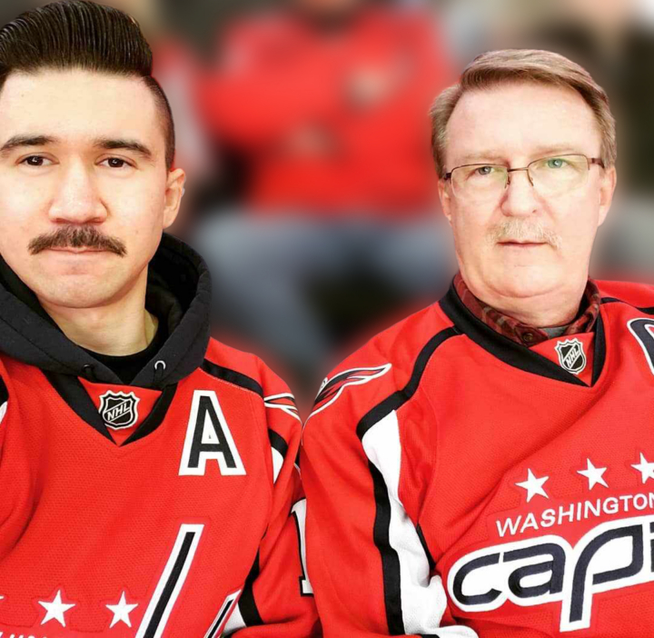 Two people wearing Washington Capitals jerseys take a photo together.