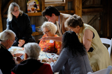 Stefan Romero, creator of the America's Tapestry project, consults with volunteer embroiderers completing one of the 13 panels