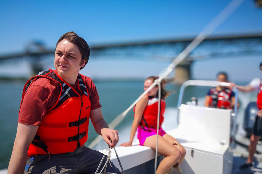 People wearing life vests sit on a boat.