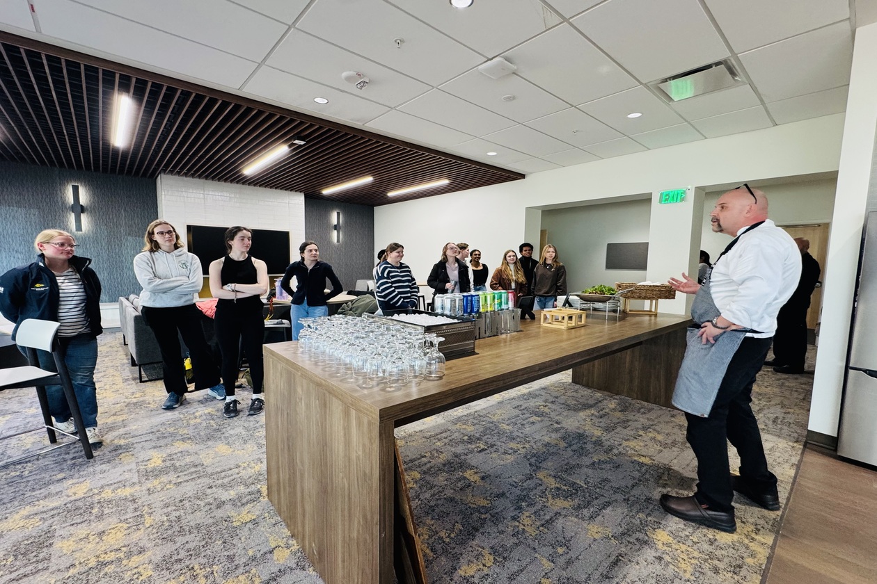 A visiting chef speaks to residents of the French House before a cooking demonstration.