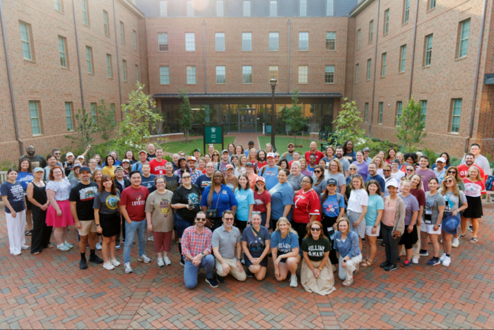 A gathering of We the Teachers attendees stand in front of White Hall for a photo.