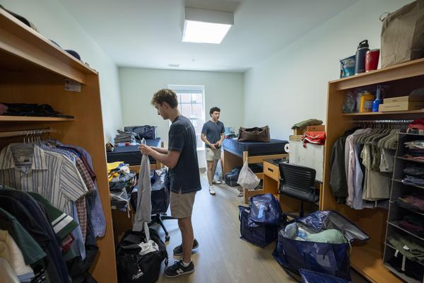 Interior of residential room as two new students unload their belongings on move-in day for the class of 2030.
