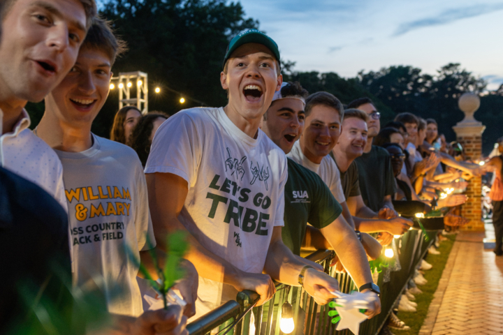 A row of students cheer in a line as new students walk through the Wren building.