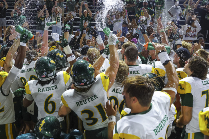 Football players celebrate by spraying water bottles into the air.