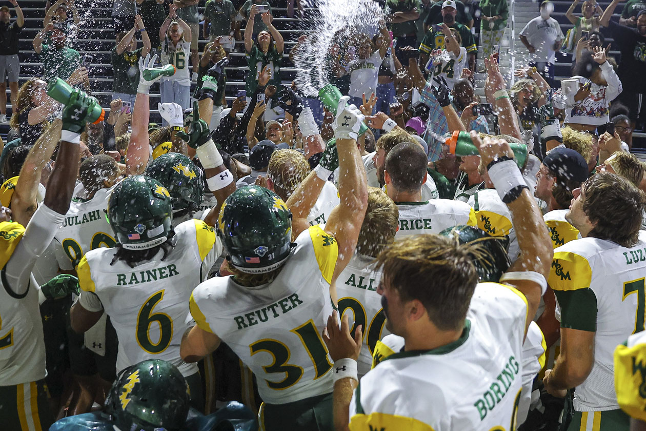 Football players celebrate by spraying water bottles into the air.