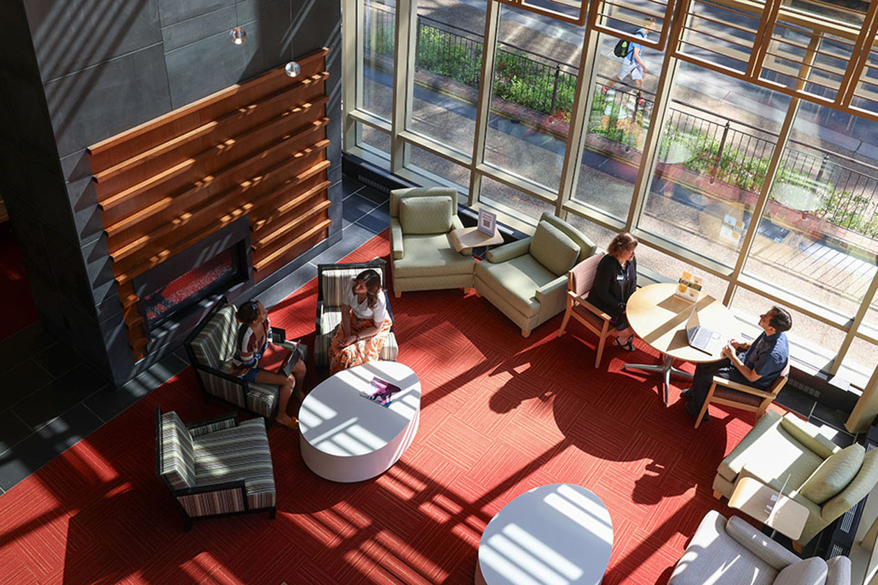 People study in large chairs in a lobby.