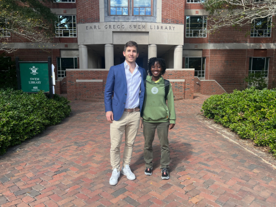 This is a photo of Will Smith '14 who founded the school Zeta Kromach '28 attended. They are posing outside Swem Library on the William & Mary campus.